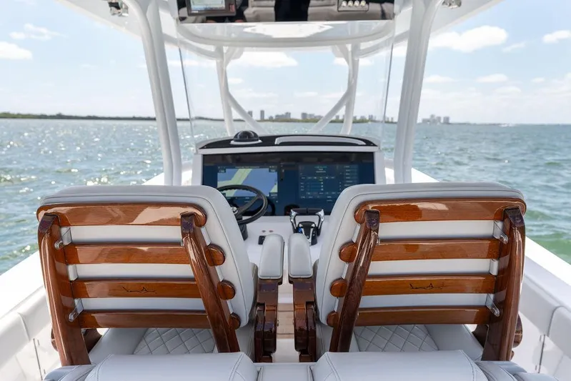  Yacht Photos Pics 2022 Jupiter 32 boat interior with wooden seats and modern dashboard on open water.