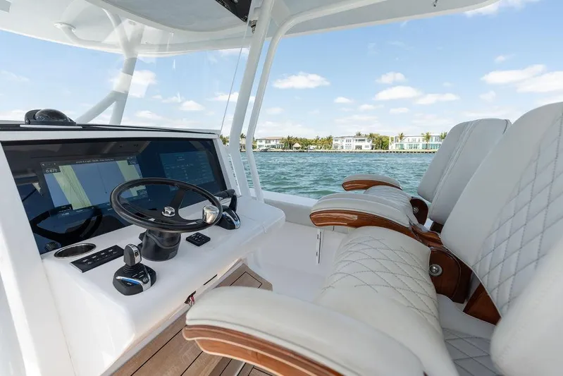  Yacht Photos Pics Luxurious 2022 Jupiter 32 boat interior with plush seating and modern controls on a sunny day.