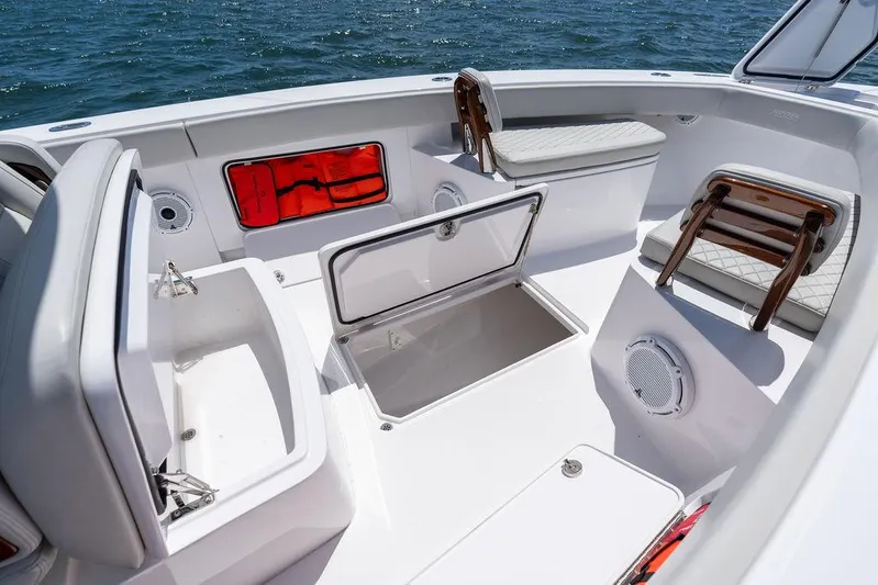  Yacht Photos Pics 2022 Jupiter 32 boat interior with open storage compartments and seating, on a sunny day at sea.
