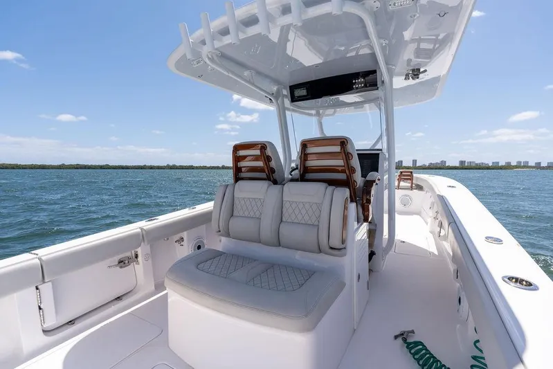  Yacht Photos Pics 2022 Jupiter 32 boat interior with cushioned seating, open water view, and clear sky.