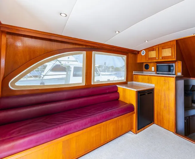  Yacht Photos Pics Luxurious 2013 Custom Express yacht interior with wood finish, maroon seating, kitchenette, and large windows.