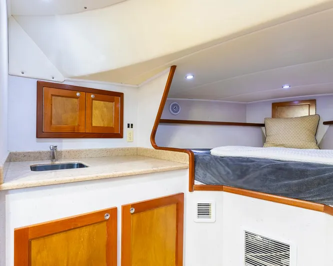  Yacht Photos Pics Cozy cabin interior of a 2013 Custom Express boat with bed, sink, and wooden cabinets.