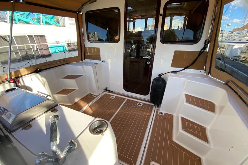 Belle Journee Yacht Photos Pics 2013 Ranger Tugs R-29 S boat interior with teak flooring and seating area.