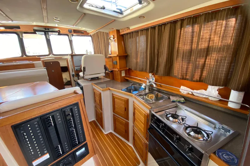 Belle Journee Yacht Photos Pics 2013 Ranger Tugs R-29 S interior with kitchen, stove, and control panel.