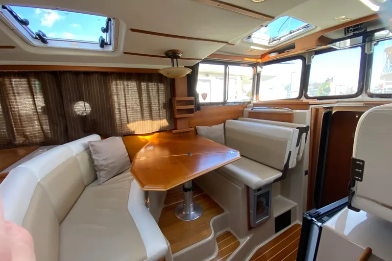 Belle Journee Yacht Photos Pics Interior of 2013 Ranger Tugs R-29 S with seating and wooden table.