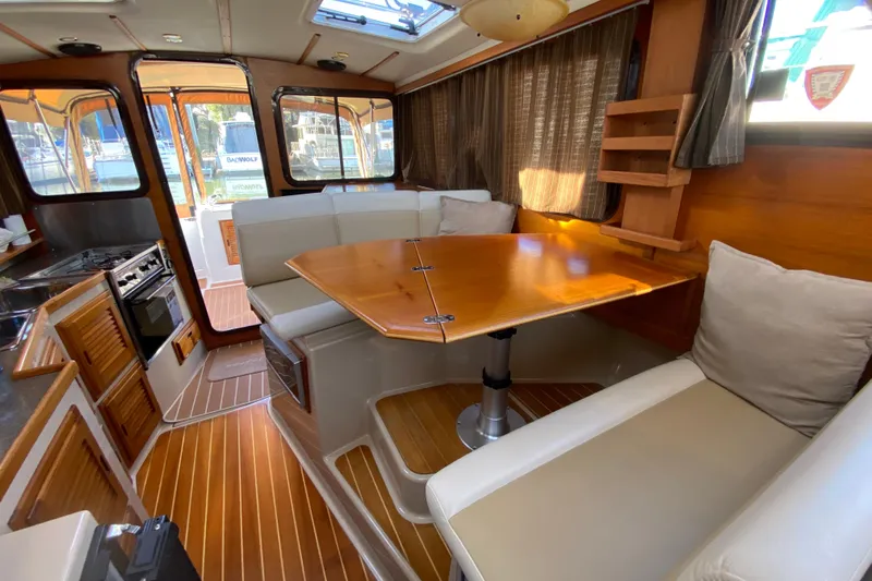 Belle Journee Yacht Photos Pics 2013 Ranger Tugs R-29 S interior with dining area and kitchen, featuring wood accents.