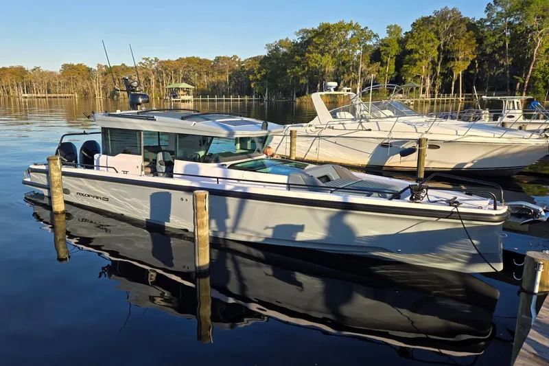 Hell Or High Waters Yacht Photos Pics 2024 Axopar 37XC CROSS CABIN docked on a serene lake with surrounding boats.