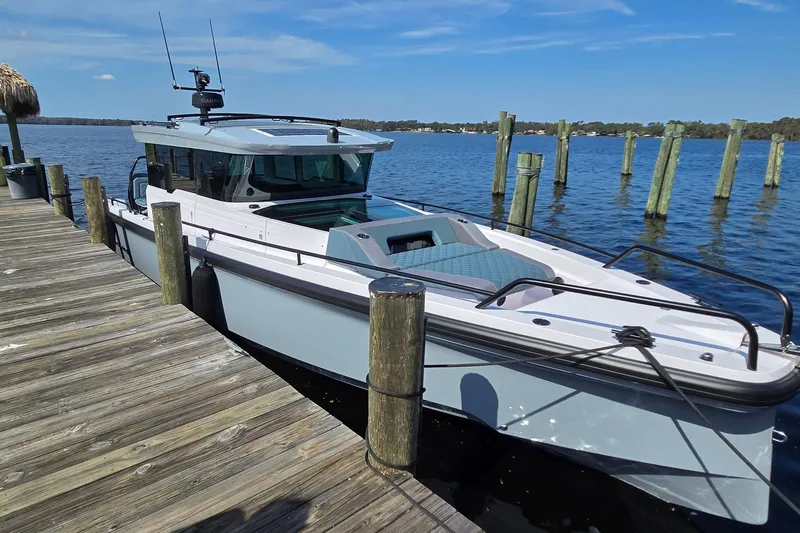 Hell Or High Waters Yacht Photos Pics 2024 Axopar 37XC CROSS CABIN docked by a wooden pier on a sunny day.