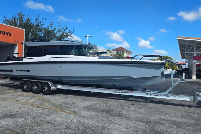 Hell Or High Waters Yacht Photos Pics 2024 Axopar 37XC CROSS CABIN boat on trailer, parked outdoors under blue sky.
