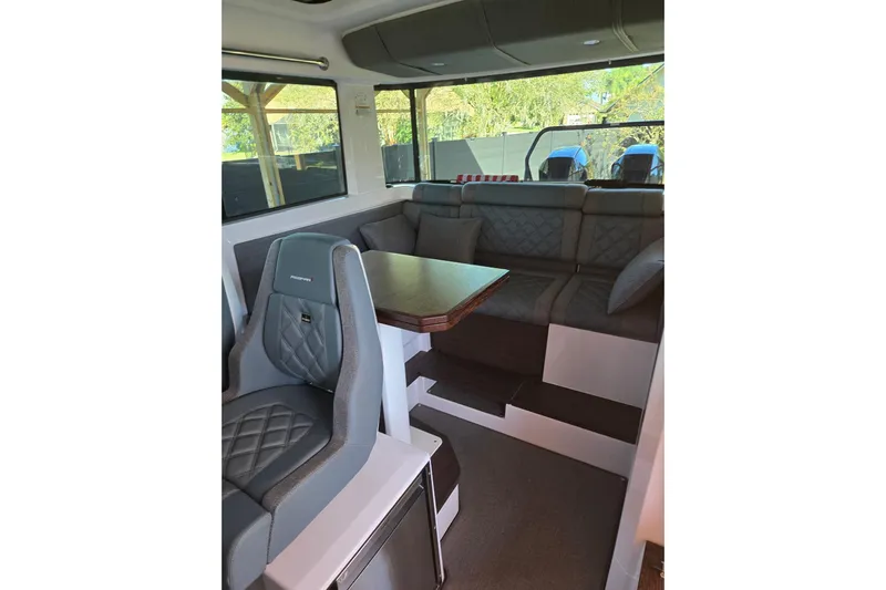 Hell Or High Waters Yacht Photos Pics 2024 Axopar 37XC CROSS CABIN interior with seating and table, featuring modern design.