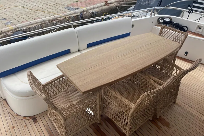 75 Princess 2008 Yacht Photos Pics Outdoor seating area on a 2008 Princess 75 Motor Yacht with wicker chairs and wooden table.