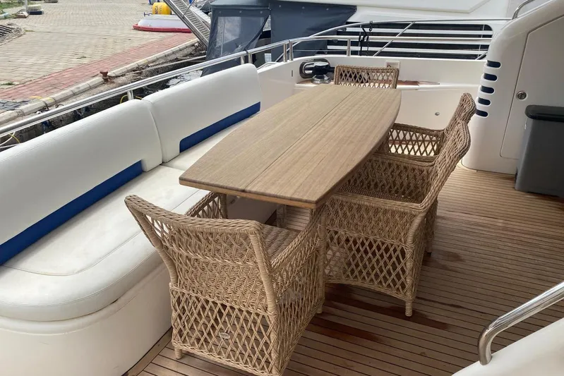 75 Princess 2008 Yacht Photos Pics Outdoor seating area on 2008 Princess 75 Motor Yacht with wicker chairs and wooden table.