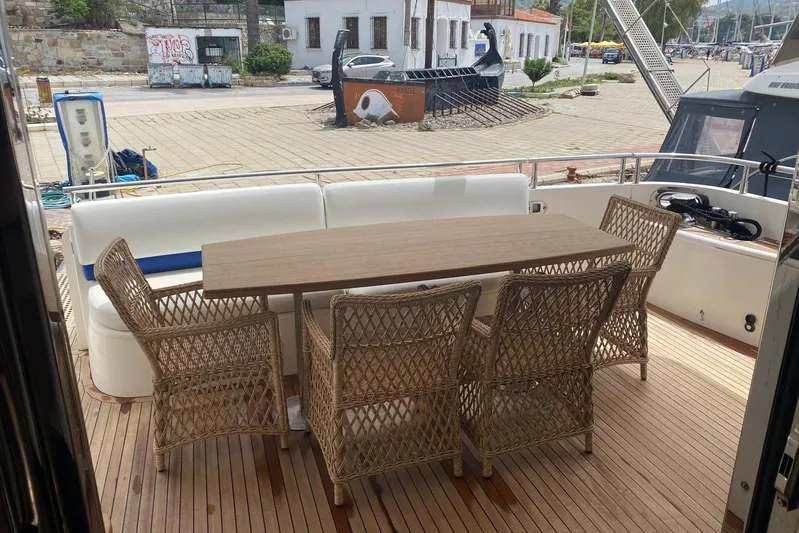 75 Princess 2008 Yacht Photos Pics Outdoor dining area on 2008 Princess 75 Motor Yacht with wicker chairs and wooden table.