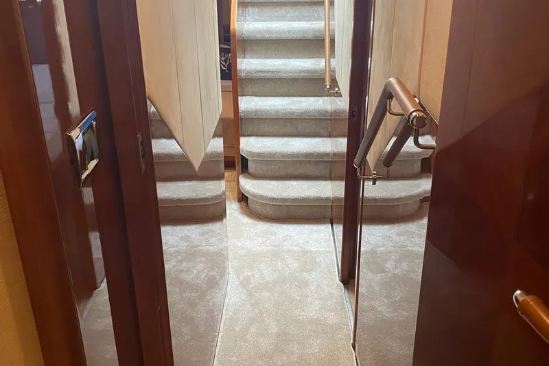 75 Princess 2008 Yacht Photos Pics Interior view of 2008 Princess 75 Motor Yacht with carpeted stairs and wooden handrails.