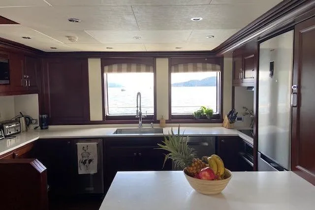 Samsara Yacht Photos Pics Luxurious 2017 Custom Dauntless yacht kitchen with ocean view, fruit bowl, and modern appliances.