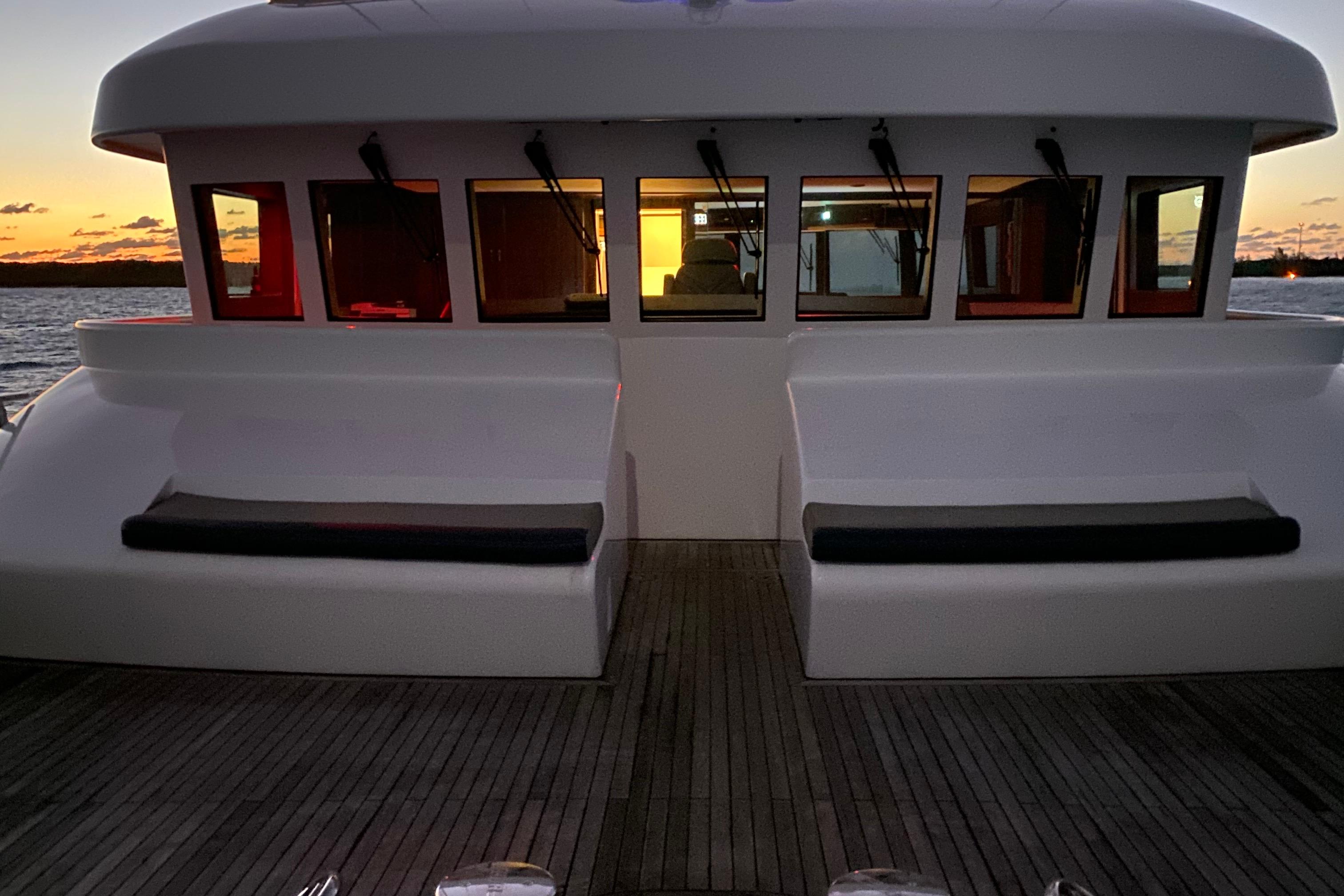 2017 Dauntless Custom boat deck at sunset with seating and windows.