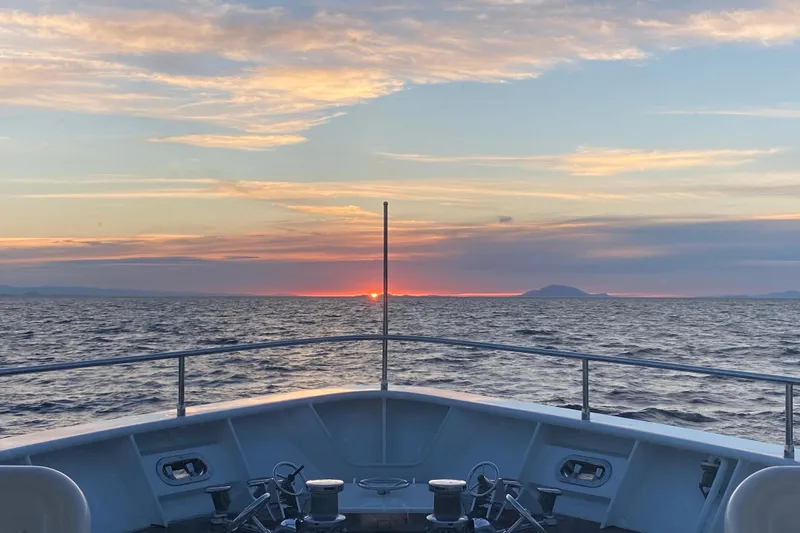 Samsara Yacht Photos Pics Bow of 2017 Dauntless Custom boat at sunset on the ocean.