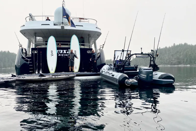 Samsara Yacht Photos Pics Luxury yacht Dauntless Custom 2017 with paddleboards and boats in serene waters.