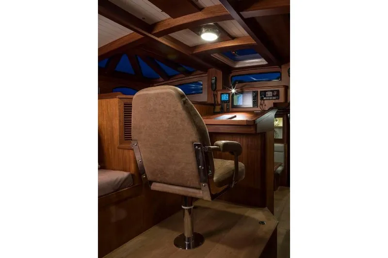 Lady Gwenhyfar Yacht Photos Pics Interior of 2018 Spirit Yachts C63, featuring a captain's chair and wooden helm.