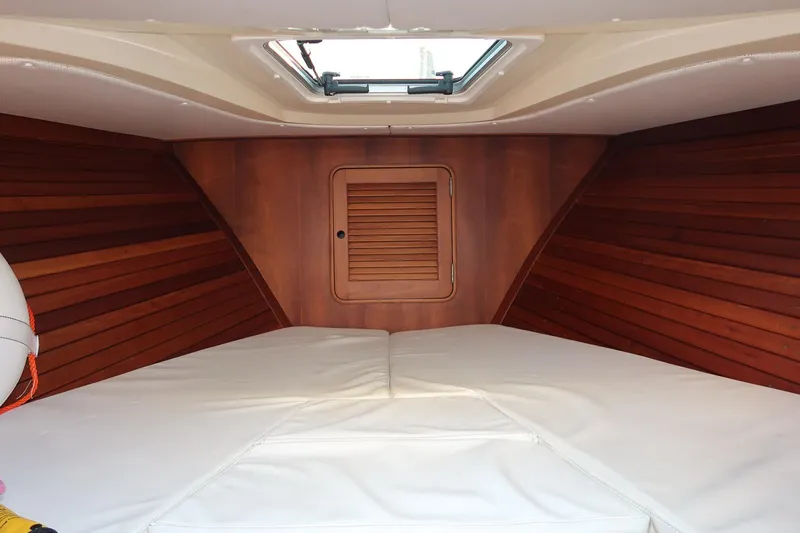 Amar Yacht Photos Pics Interior cabin of 2004 Hinckley Talaria 29 Runabout with wood paneling and white cushions.