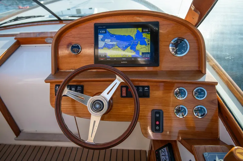 Amar Yacht Photos Pics 2004 Hinckley Talaria 29 Runabout dashboard with wooden steering wheel and navigation display.