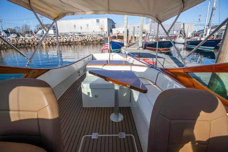 Amar Yacht Photos Pics 2004 Hinckley Talaria 29 Runabout with elegant seating and wooden table, docked at marina.