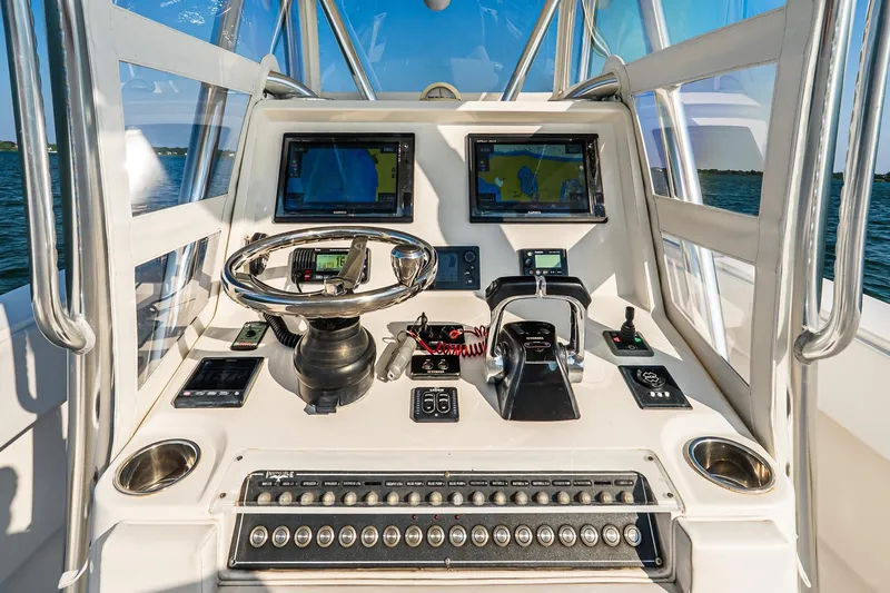 Blue Eyes Yacht Photos Pics 2016 Invincible 33 Open Fisherman helm with dual displays and controls on open water.