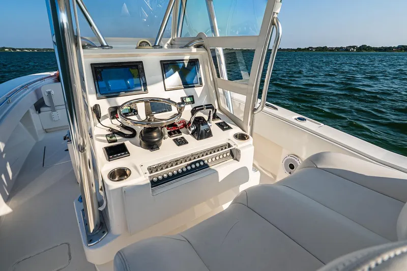 Blue Eyes Yacht Photos Pics 2016 Invincible 33 Open Fisherman boat dashboard with navigation screens on open water.