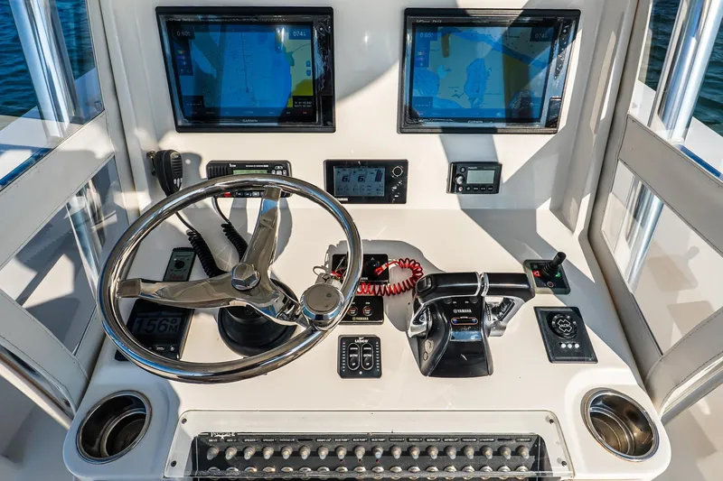 Blue Eyes Yacht Photos Pics Control panel of 2016 Invincible 33 Open Fisherman with steering wheel and navigation screens.