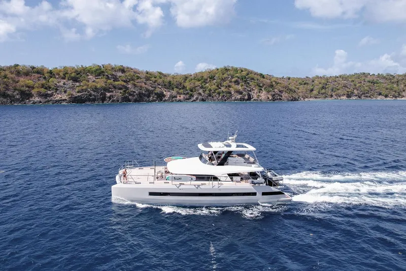 Cest La Vie Yacht Photos Pics 2022 Lagoon SIXTY 7 yacht cruising in blue ocean near lush island.