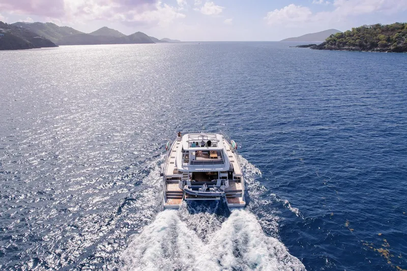 Cest La Vie Yacht Photos Pics Lagoon SIXTY 7 yacht cruising on open sea, 2022 model, surrounded by scenic coastline.