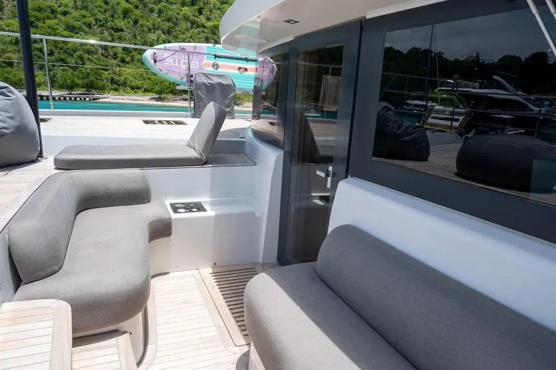 Cest La Vie Yacht Photos Pics Luxurious 2022 Lagoon SIXTY 7 yacht deck with comfortable seating and scenic view.