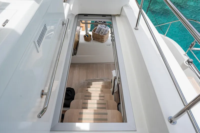 Cest La Vie Yacht Photos Pics Stairway on 2022 Lagoon SIXTY 7 yacht, leading to interior with basket and towels.
