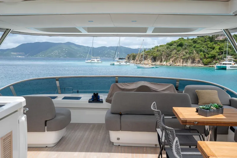 Cest La Vie Yacht Photos Pics Luxurious 2022 Lagoon SIXTY 7 yacht deck with scenic ocean view and anchored boats.