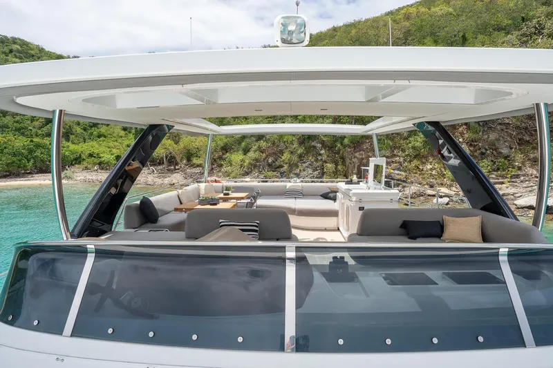 Cest La Vie Yacht Photos Pics Luxurious 2022 Lagoon SIXTY 7 yacht with spacious outdoor seating and scenic coastal backdrop.