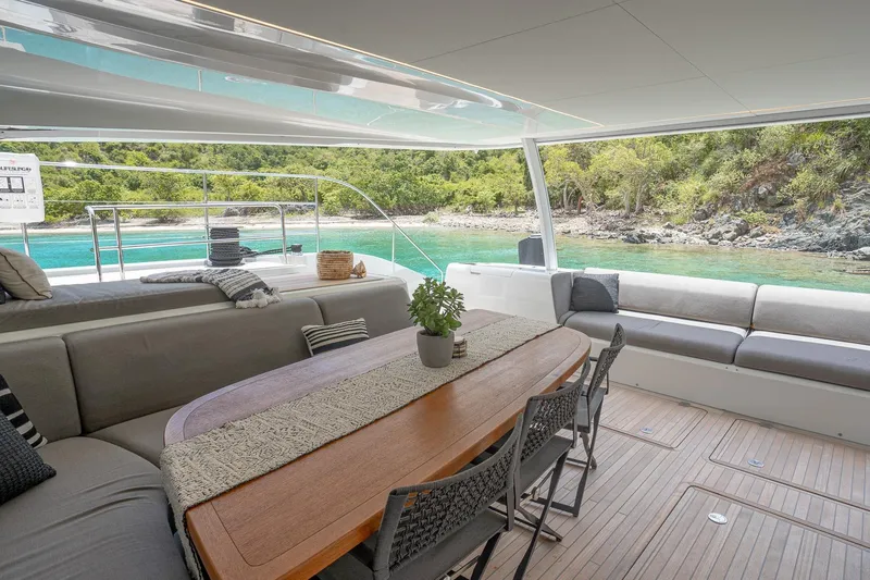 Cest La Vie Yacht Photos Pics Luxurious Lagoon SIXTY 7 yacht interior with elegant seating, overlooking serene turquoise waters, 2022 model.