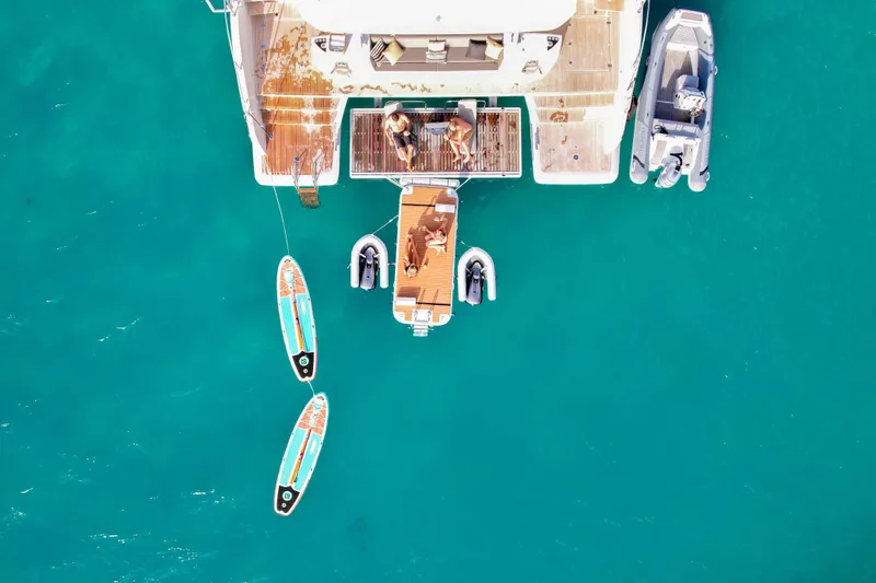 Cest La Vie Yacht Photos Pics Aerial view of 2022 Lagoon SIXTY 7 yacht with paddleboards and clear turquoise water.