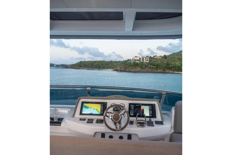 Cest La Vie Yacht Photos Pics Lagoon SIXTY 7 yacht helm with navigation screens, overlooking serene coastal waters.