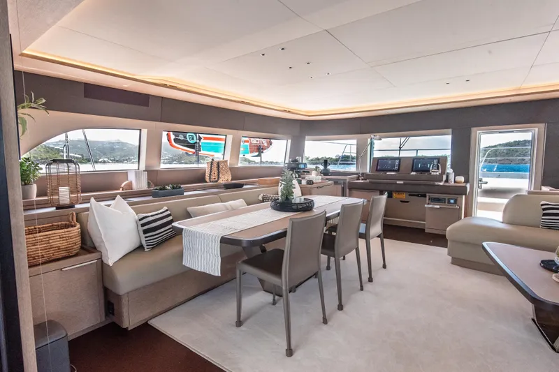 Cest La Vie Yacht Photos Pics Luxurious interior of 2022 Lagoon SIXTY 7 yacht with elegant dining area and panoramic windows.