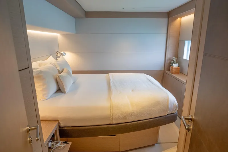 Cest La Vie Yacht Photos Pics Luxurious bedroom interior of 2022 Lagoon SIXTY 7 yacht, featuring modern design and cozy ambiance.