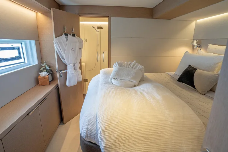Cest La Vie Yacht Photos Pics Luxurious bedroom interior of 2022 Lagoon SIXTY 7 yacht with elegant bedding and modern decor.