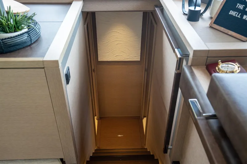 Cest La Vie Yacht Photos Pics Interior of 2022 Lagoon SIXTY 7 yacht, featuring elegant wooden staircase and modern decor.