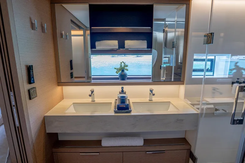 Cest La Vie Yacht Photos Pics Luxurious bathroom interior of 2022 Lagoon SIXTY 7 yacht with dual sinks and modern design.
