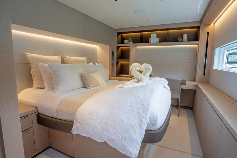 Cest La Vie Yacht Photos Pics Luxurious bedroom interior of 2022 Lagoon SIXTY 7 yacht with elegant decor and ambient lighting.