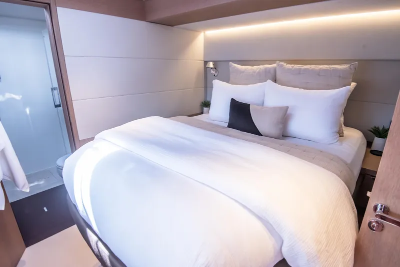 Cest La Vie Yacht Photos Pics Luxurious bedroom interior of 2022 Lagoon SIXTY 7 yacht with modern design and cozy bedding.
