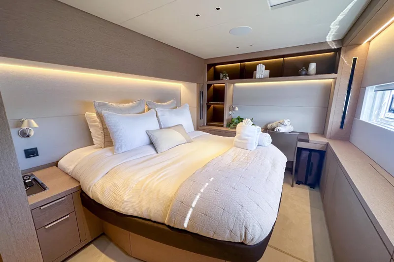 Cest La Vie Yacht Photos Pics Luxurious bedroom interior of 2022 Lagoon SIXTY 7 yacht with modern design and cozy bedding.