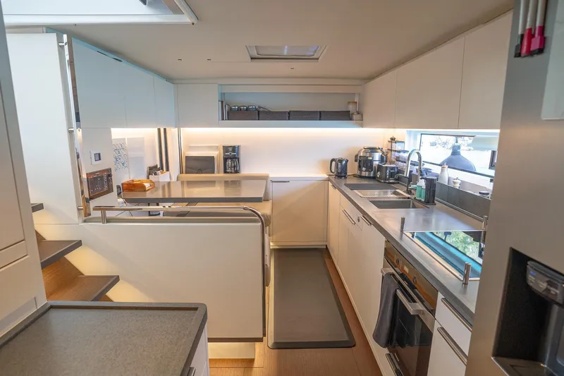 Cest La Vie Yacht Photos Pics Modern kitchen interior on 2022 Lagoon SIXTY 7 yacht, featuring sleek design and appliances.