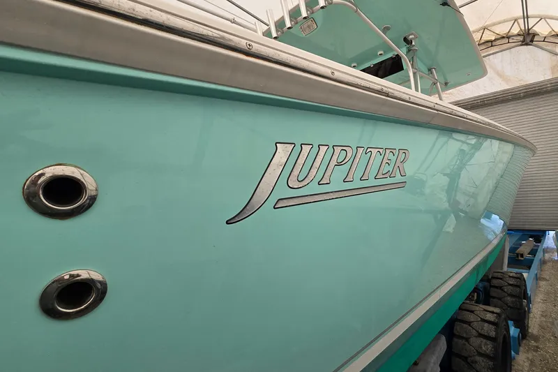  Yacht Photos Pics 2010 Jupiter 34 FS boat in storage, showcasing sleek turquoise hull design.