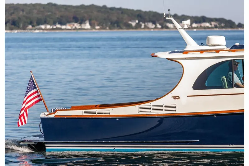 Pisces Yacht Photos Pics 2017 Hinckley Picnic Boat MKIII cruising with American flag on calm waters.