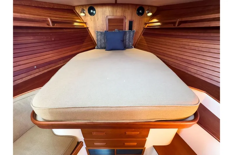 Pisces Yacht Photos Pics 2017 Hinckley Picnic Boat MKIII interior cabin with cozy bed and wooden paneling.